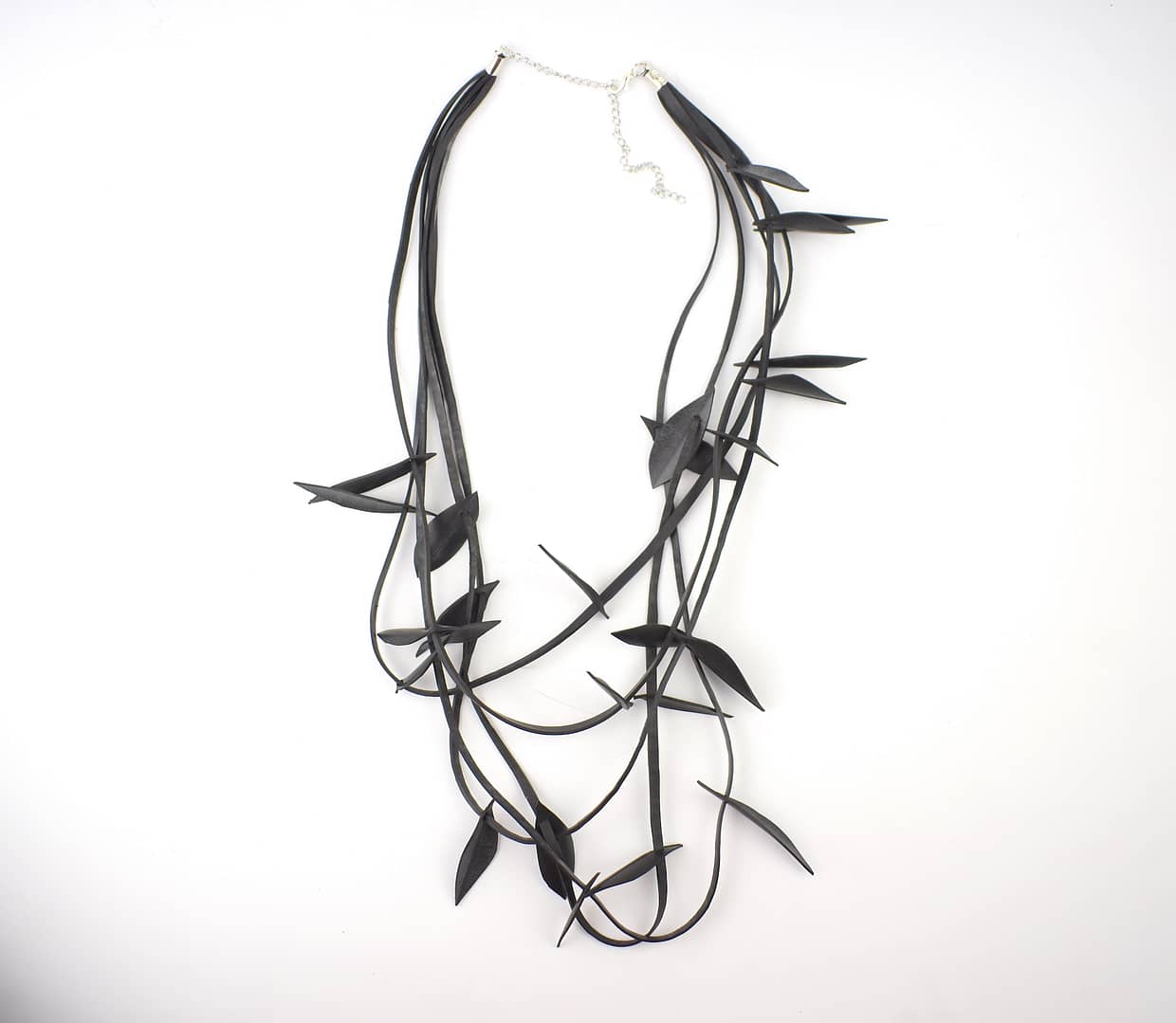 Recyled Jewellery: A multi-strand Birds on Wire Necklace featuring black faux leather ribbons and metallic arrowhead accents, crafted from repurposed materials, displayed against a white background. @ Reblack Shop