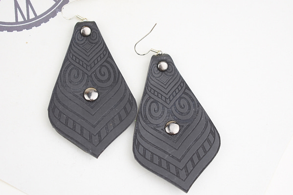 Recyled Jewellery: A pair of black geometric-patterned earrings, featuring silver embellishments and crafted from repurposing jewelry, placed on a light background. @ Reblack Shop