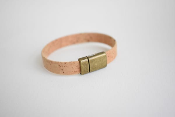 Recyled Jewellery: A simple recycled cork bracelet with a golden clasp on a white background. @ Reblack Shop