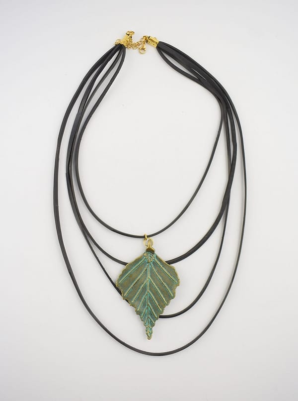 Recyled Jewellery: Multi-strand necklace with an eco-friendly gold and turquoise enameled leaf pendant, displayed against a plain white background. @ Reblack Shop