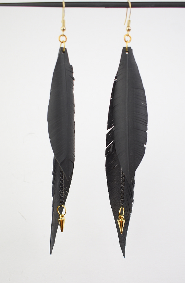 Recyled Jewellery: A pair of Feather Cut Golden Arrow earrings, crafted from eco-friendly materials, hanging from gold hooks with detailed textures on the feathers, set against a white background. @ Reblack Shop